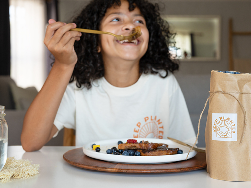 Young girl eating Keep Planted pancakes
